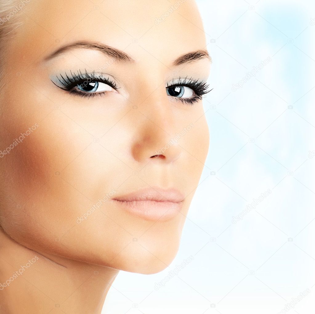Beautiful female face over abstract blue sky background