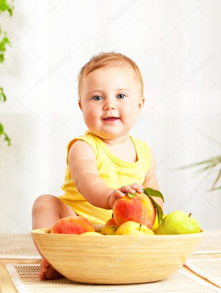 Little baby holding fresh fruits