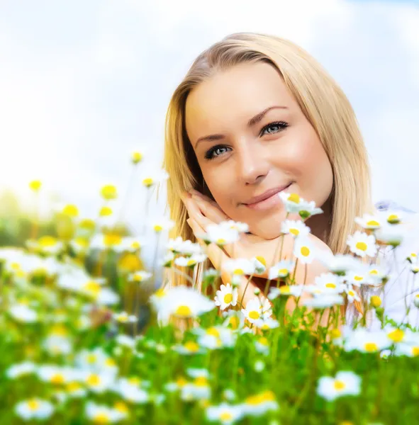Schöne Frau genießt Gänseblümchenfeld und blauen Himmel — Stockfoto