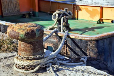 Boat moorings oxidized in a fishing port clipart