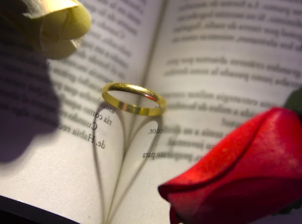 Gold ring and book a romantic heart forming — Stock Photo, Image