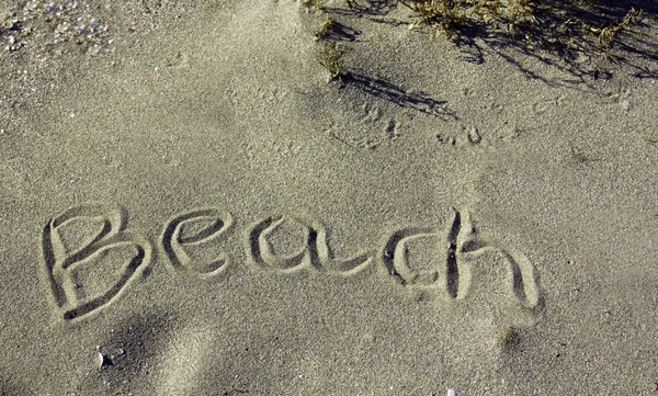 Plaj kumsalında, üzerinde kelimeler yazılı. — Stok fotoğraf
