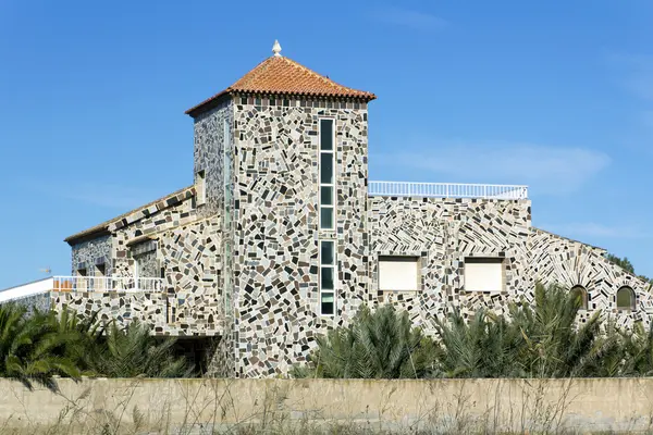 Kurioses Haus mit farbigen Steinen in den Wänden — Stockfoto