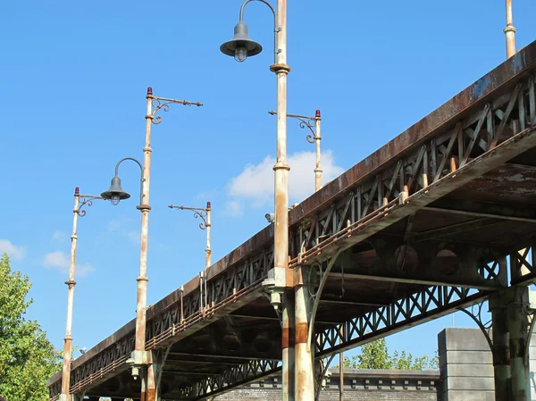 Vieux pont de fer oxydé avec des lampadaires — Photo