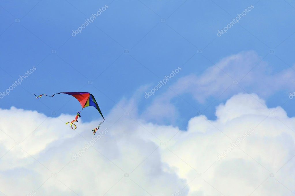 Rainbow colored kite in the clouds