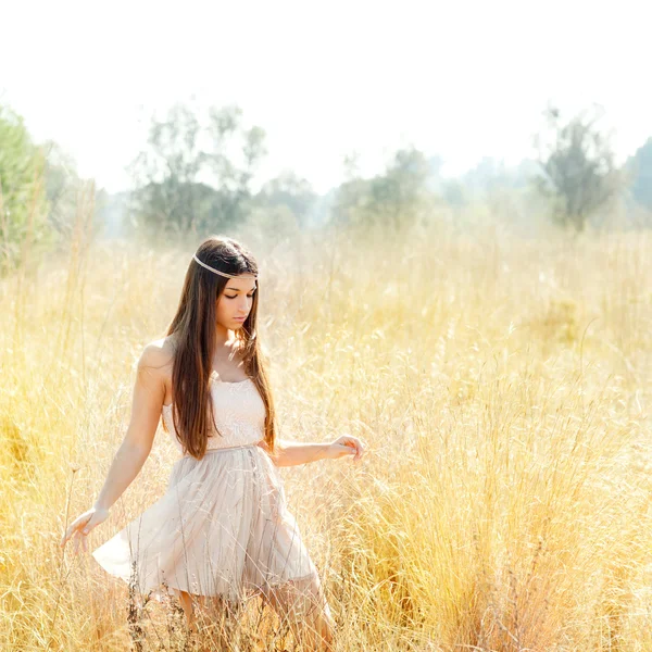 Asian indian woman walking in golden dried field — Stock Photo, Image