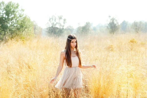 Asian indian woman walking in golden dried field — Stock Photo, Image