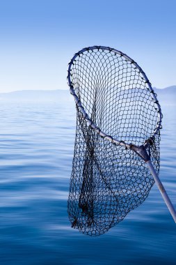 Fishing landing net in blue sea clipart