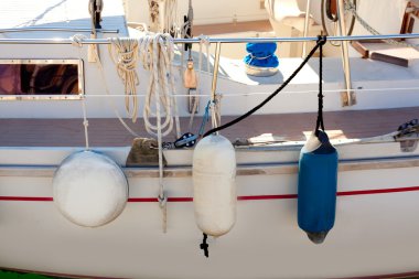 Fender buoys on sailboat side with ropes clipart