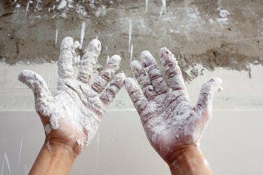 Astist plastering man hands with cracked plaster clipart