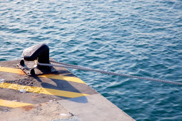 Bolder in de haven met touw lus rond — Stockfoto