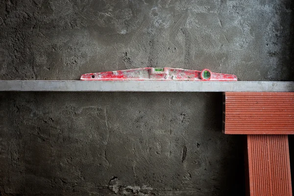 Bublinkové vodováhy nástroj v červené barvě na tvorba dokázaných cementu — Stock fotografie