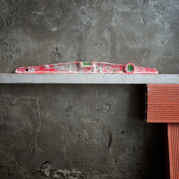 Konstrüksiyon çimento üzerinde kırmızı balonu ruh düzeyi aracı — Stok fotoğraf