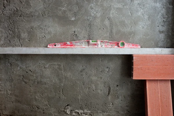 Bublinkové vodováhy nástroj v červené barvě na tvorba dokázaných cementu — Stock fotografie