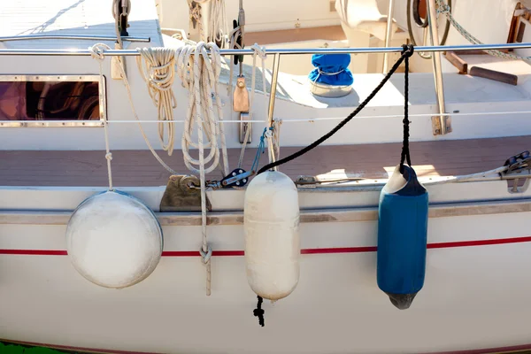 Fender buoys on sailboat side with ropes — Stock Photo, Image