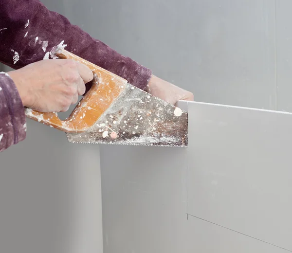 Cutting plasterboard plaster hand dirty saw — Stock Photo, Image