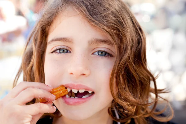 Churro kızarmış lokma yiyen küçük kız mavi gözler — Stok fotoğraf