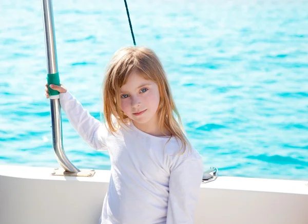 Blond dziewczynka dziecko żeglarstwo w łodzi uśmiechający się — Zdjęcie stockowe
