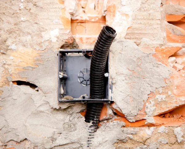 ボックスの壁に埋め込まれたコイルの電気コンジット パイプ — ストック写真