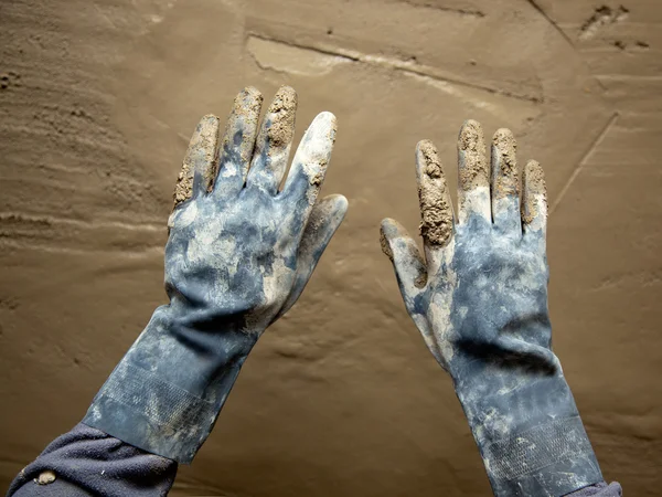 Guantes grunge sucios manos en la pared mortero de cemento —  Fotos de Stock