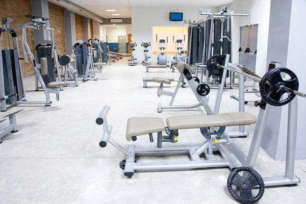 Fitness club gimnasio con equipamiento deportivo interior — Foto de Stock