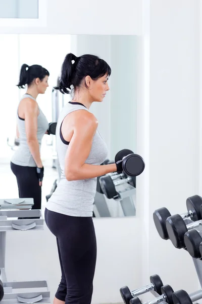 Mulher com equipamento de treinamento de peso no ginásio esporte — Fotografia de Stock
