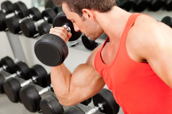 Hombre con equipo de entrenamiento con pesas en gimnasio deportivo — Foto de Stock