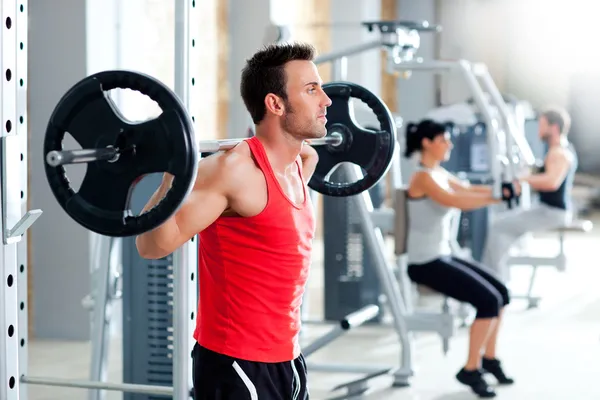 哑铃重量训练设备健身房的男人 — 图库照片