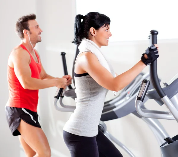 男人和女人与椭圆交叉训练机在健身房 — 图库照片