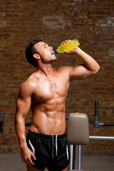 Uomo muscolare in palestra rilassato con bevanda energetica — Foto Stock