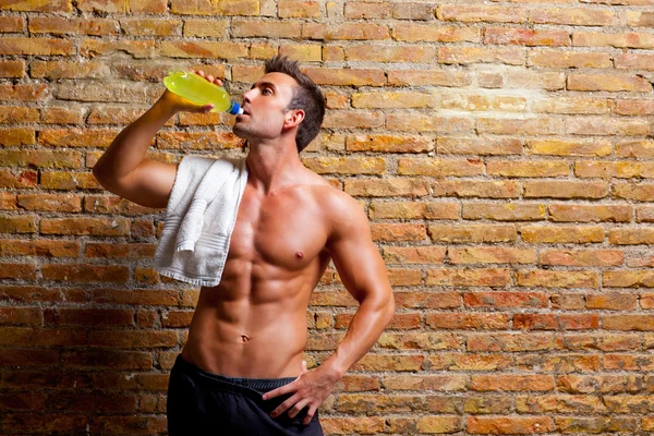 Мужчина в форме мышцы в спортзале расслабился, выпивая — стоковое фото