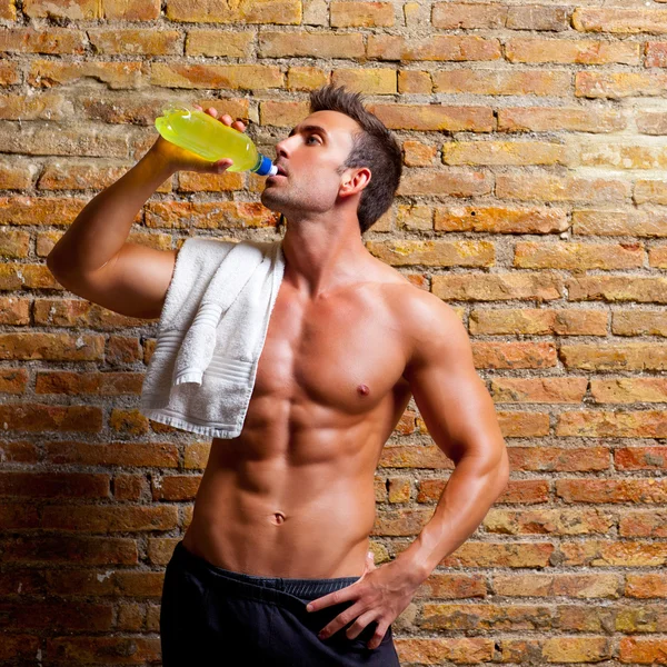 Мужчина в форме мышцы в спортзале расслабился, выпивая — стоковое фото