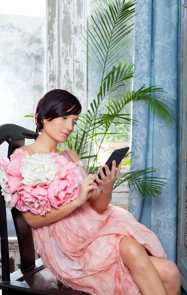Moda kobieta i tabletki ebook czytanie z sukienka kwiaty — Zdjęcie stockowe