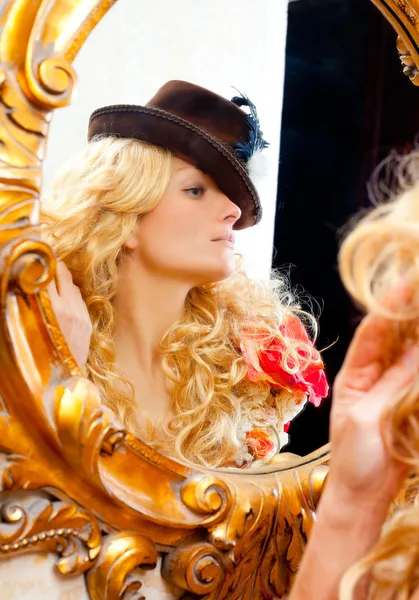 Mode blonde vrouw met hoed in barokke Gouden spiegel — Stockfoto
