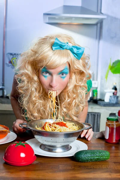 Blondin rolig på kök äta pasta som galen — Stockfoto