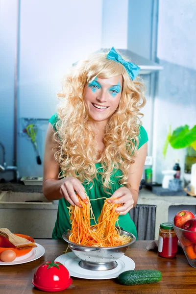 Moda loira engraçado na cozinha com macarrão e — Fotografia de Stock