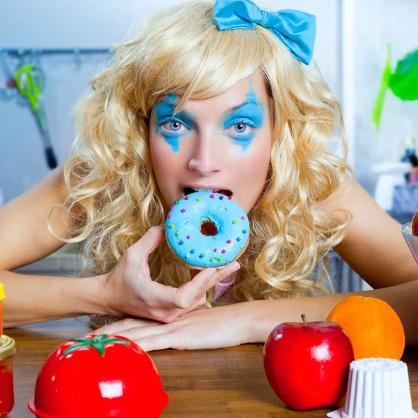 Loira engraçado menina na cozinha comendo dona azul — Fotografia de Stock