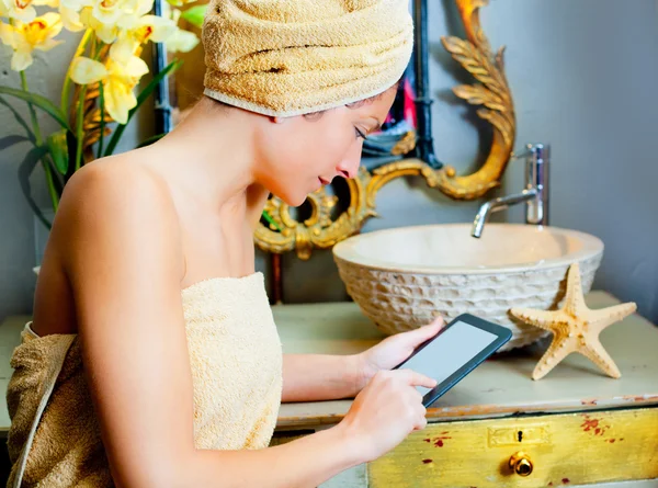 Kobieta w bathroomreading ebook tabletki — Zdjęcie stockowe