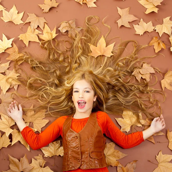 Herfst val beetje blond meisje op gedroogde boom bladeren — Stockfoto