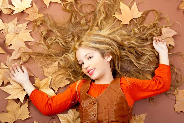 Jesień, trochę blond dziewczynka na drzewo suszonych liści — Zdjęcie stockowe