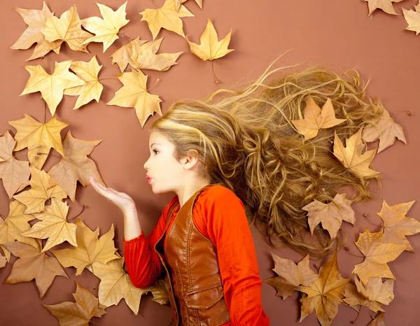 Autumn girl on dried leaves blowing wind lips — Stock Photo, Image
