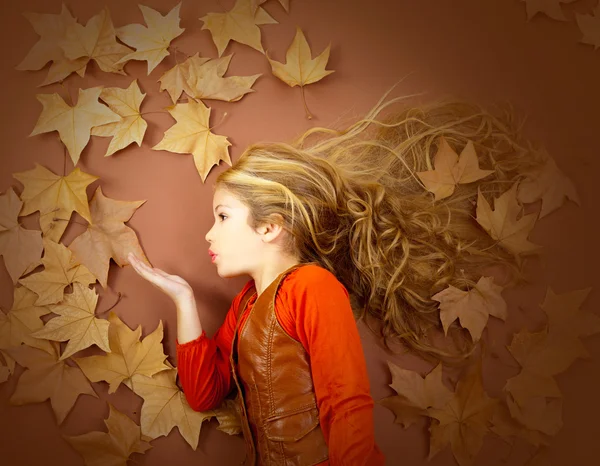 Φθινόπωρο κορίτσι σε αποξηραμένα φύλλα φυσώντας άνεμος χείλη — Φωτογραφία Αρχείου
