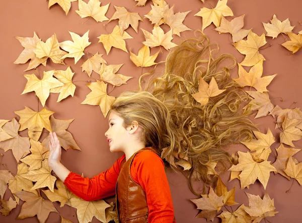 Autumn girl on dried leaves — Stockfoto