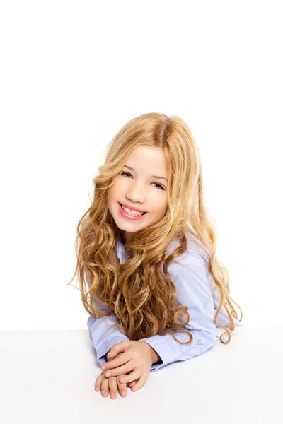 Blond kid liten flicka stående leende på ett skrivbord i vitt — Stockfoto