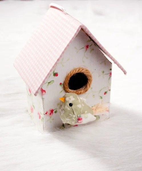 Bird in a nest fabric house with round window — Stock Photo, Image