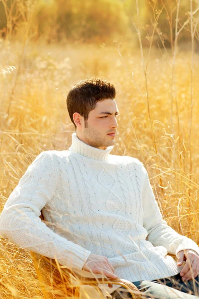 Осенний портрет зимнего человека в сухой траве — стоковое фото