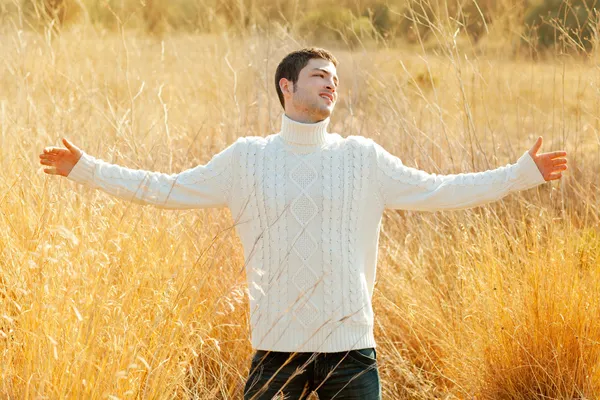 Осенний человек в золотом поле со свитером в водолазке — стоковое фото