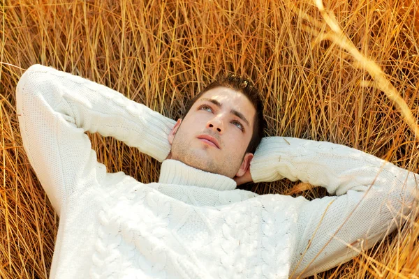 秋冬季男人肖像躺在金色的草坪 — 图库照片