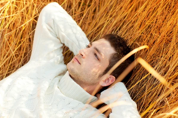 Outono homem de inverno retrato que coloca na grama dourada — Fotografia de Stock