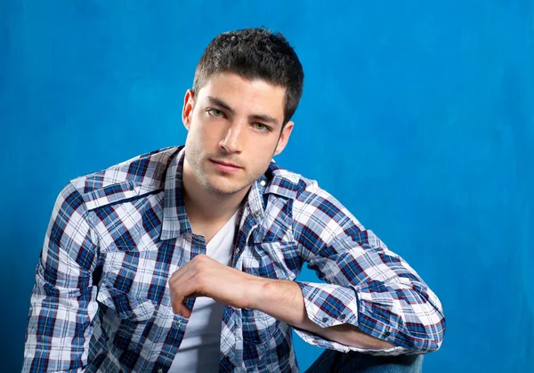Красивый молодой человек в клетчатой рубашке на голубой — стоковое фото